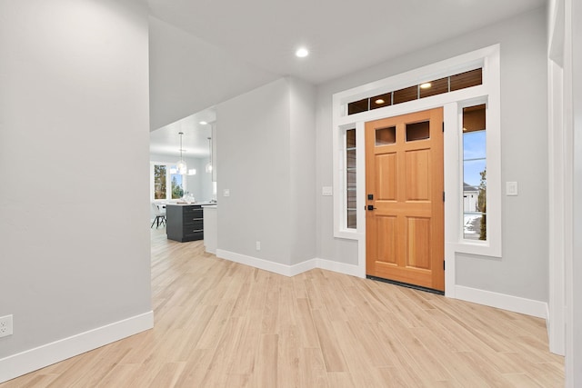 entryway featuring an inviting chandelier and light hardwood / wood-style floors