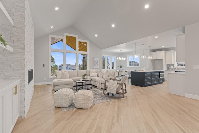 living room featuring light hardwood / wood-style flooring, a fireplace, and high vaulted ceiling