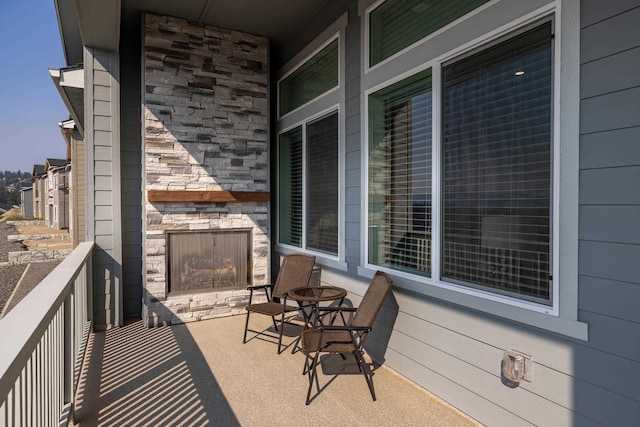 balcony featuring an outdoor stone fireplace