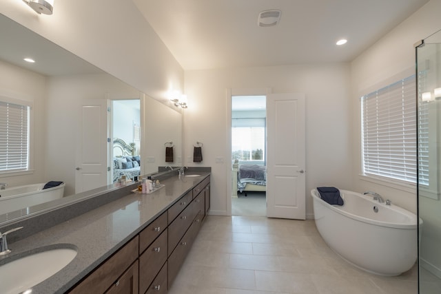 bathroom with a tub, tile patterned flooring, and vanity