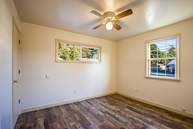 spare room with dark hardwood / wood-style floors, ceiling fan, and a healthy amount of sunlight