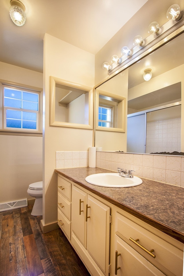 bathroom featuring an enclosed shower, vanity, toilet, and wood-type flooring