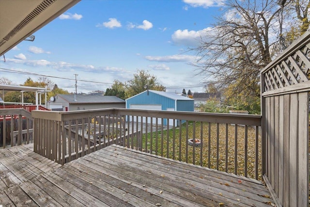 deck with a lawn, a garage, and an outbuilding