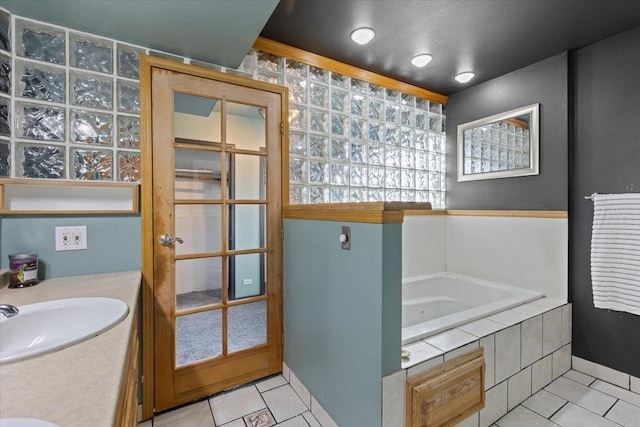 bathroom with tiled bath, tile patterned flooring, vanity, and ornamental molding