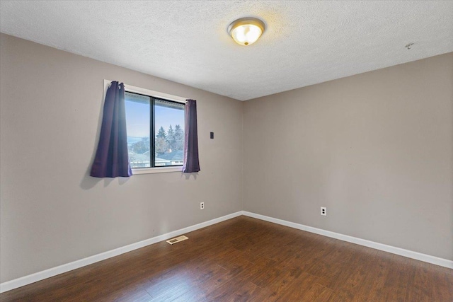 unfurnished room featuring hardwood / wood-style floors and a textured ceiling