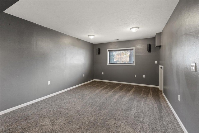 carpeted empty room featuring a textured ceiling