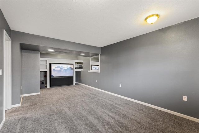 unfurnished living room featuring carpet, built in features, and a textured ceiling