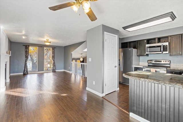 kitchen with light stone countertops, dark hardwood / wood-style flooring, a textured ceiling, stainless steel appliances, and ceiling fan