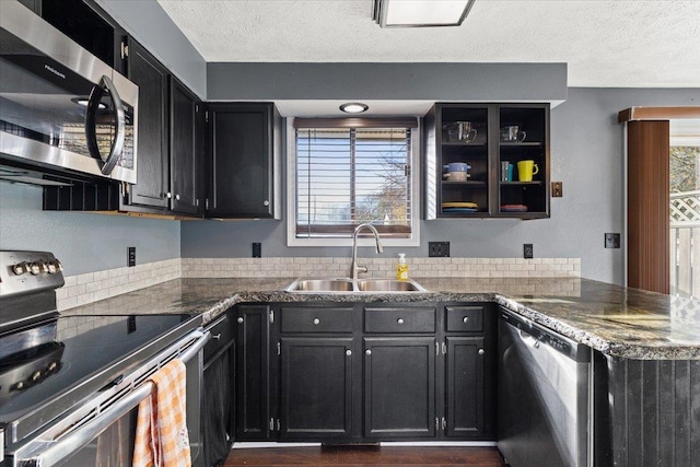 kitchen featuring a textured ceiling, dark hardwood / wood-style floors, sink, and appliances with stainless steel finishes