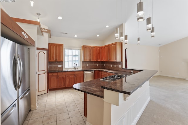 kitchen featuring backsplash, dark stone counters, a breakfast bar, stainless steel appliances, and pendant lighting