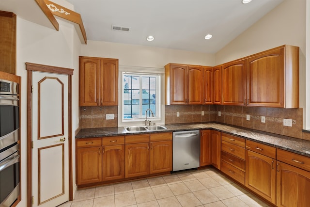 kitchen featuring light tile patterned floors, stainless steel appliances, vaulted ceiling, and sink