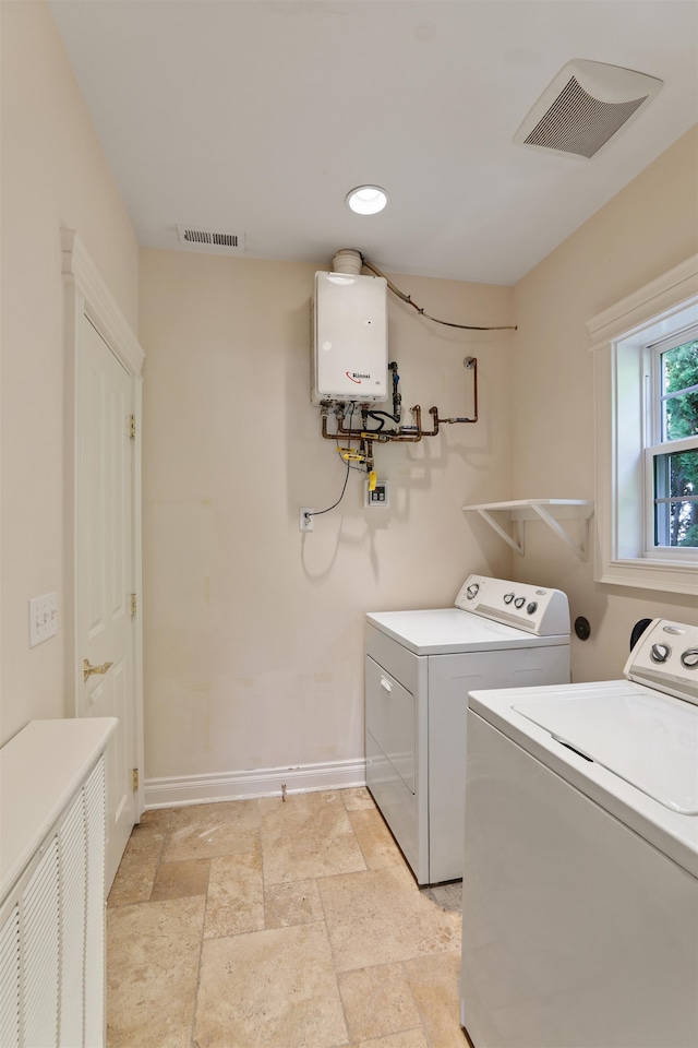 clothes washing area featuring washing machine and clothes dryer and water heater