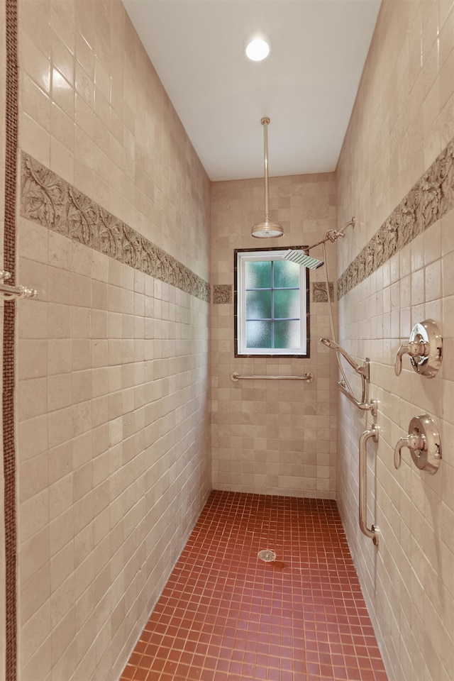 bathroom with a tile shower, tile patterned floors, and tile walls