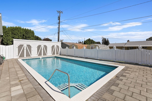 view of swimming pool with a patio and an outdoor structure