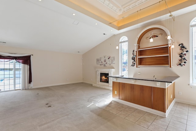 kitchen featuring high vaulted ceiling, light carpet, and a wealth of natural light