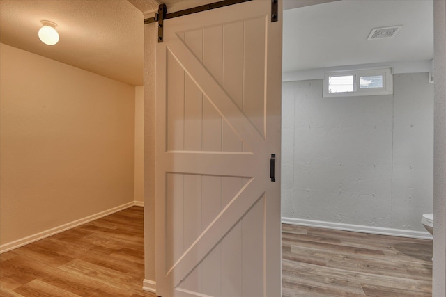 interior space with a barn door and wood-type flooring