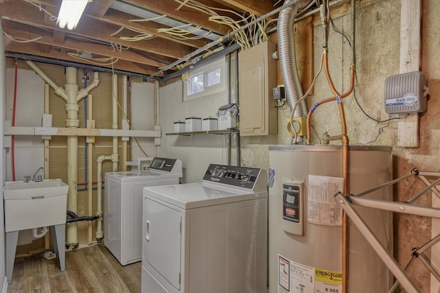 laundry room featuring washing machine and dryer, light hardwood / wood-style flooring, and water heater