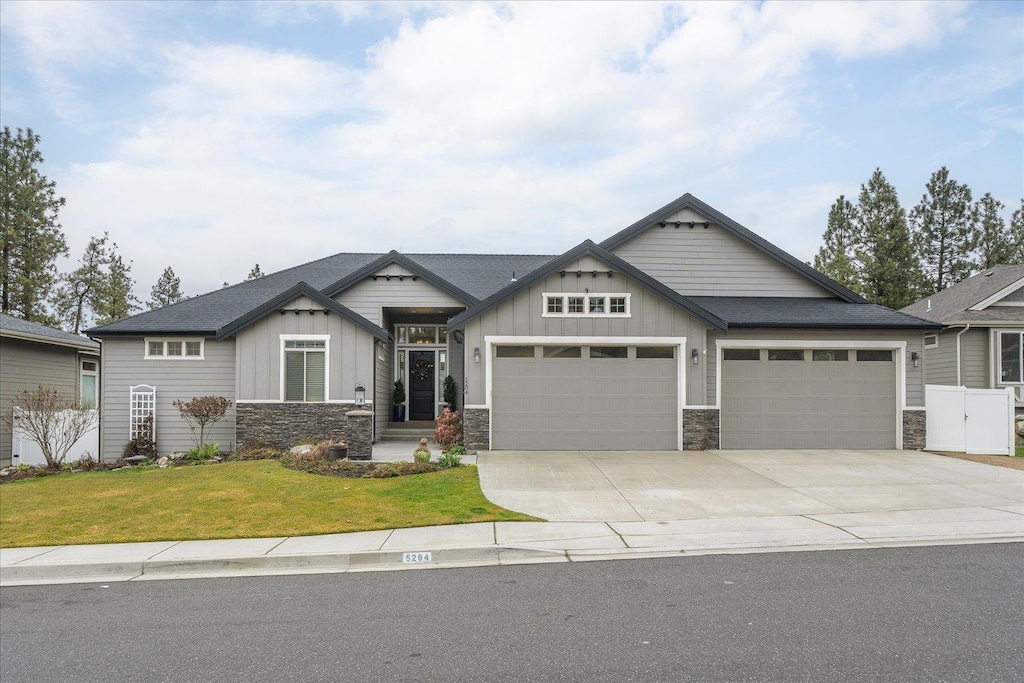 craftsman house with a garage and a front lawn