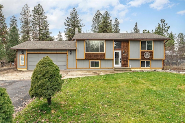 raised ranch with a garage and a front lawn