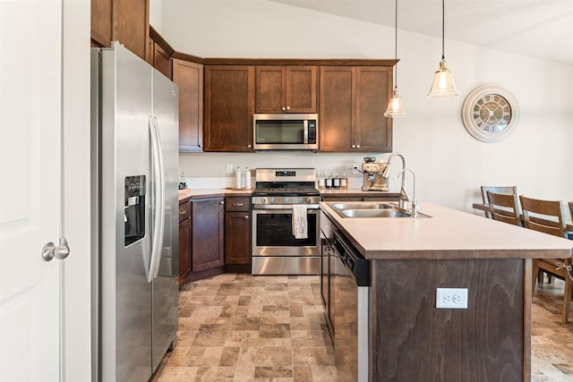 kitchen with sink, hanging light fixtures, stainless steel appliances, an island with sink, and lofted ceiling