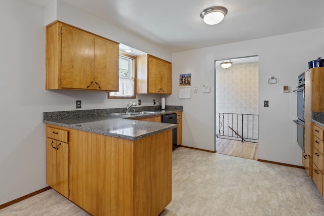 kitchen featuring dishwasher, dark stone counters, sink, multiple ovens, and kitchen peninsula