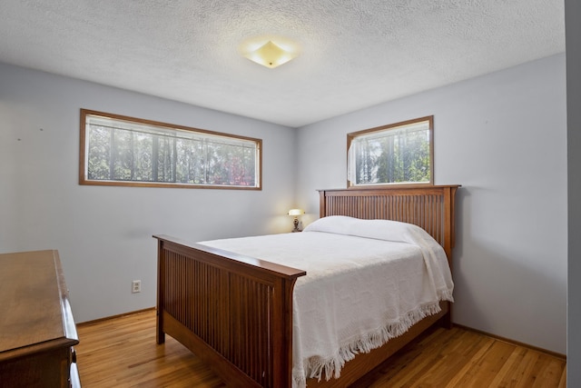 bedroom featuring light wood-type flooring and a textured ceiling