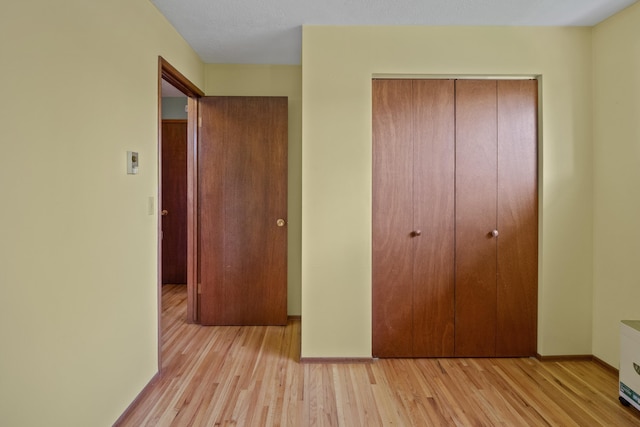 unfurnished bedroom featuring light wood-type flooring and a closet