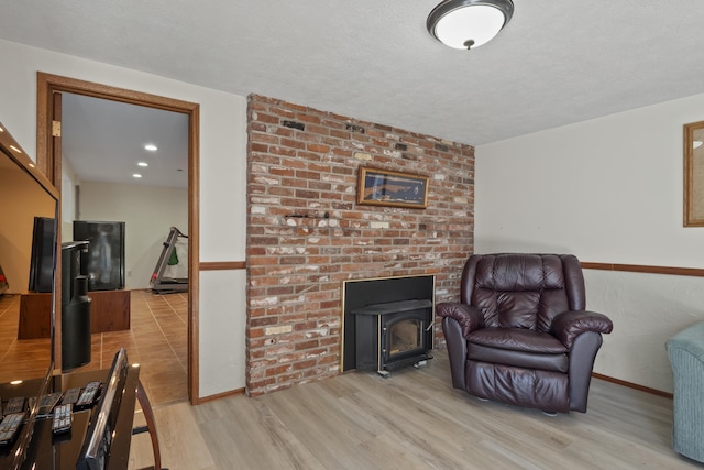 sitting room with light wood-type flooring and a wood stove