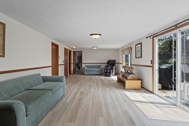 living room featuring a textured ceiling and light hardwood / wood-style floors