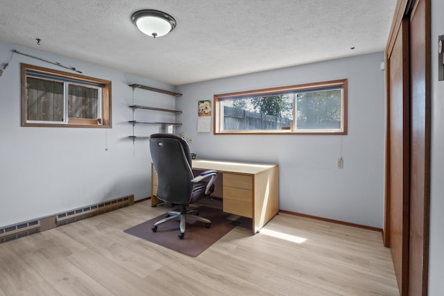 office featuring light wood-type flooring, a textured ceiling, and a baseboard heating unit