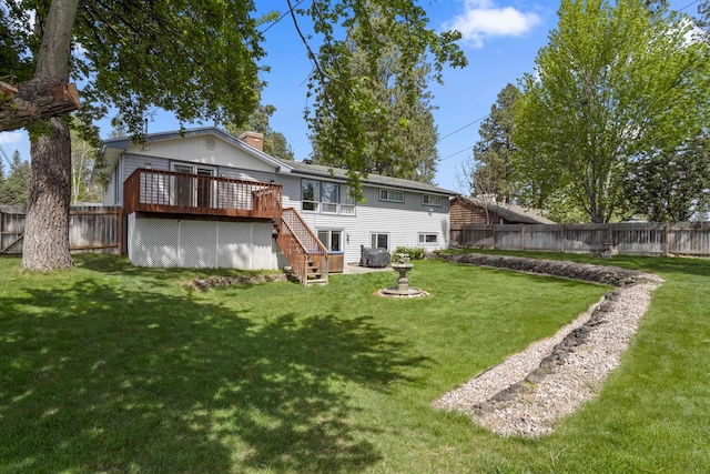 back of house featuring a lawn and a wooden deck