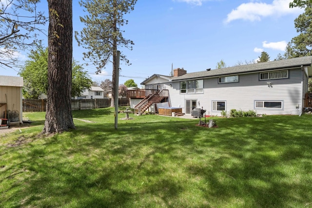 rear view of house featuring a wooden deck and a yard