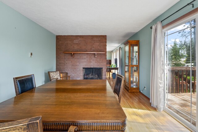 dining space featuring light hardwood / wood-style floors and a fireplace