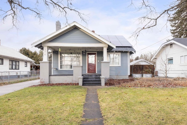 bungalow with solar panels and a front lawn