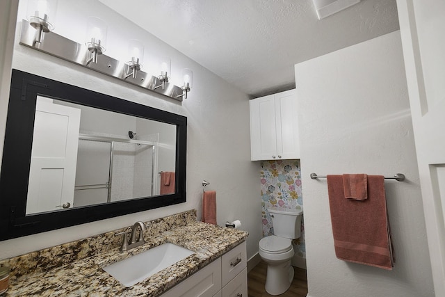 1323 E Deerhaven Ave Dalton Gardens, Dalton Gardens, Coeur D Alene, ID 83815 - bathroom featuring vanity, a textured ceiling, hardwood / wood-style floors, toilet, and a shower with shower door