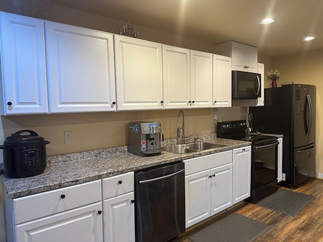 kitchen with white cabinets, sink, dark wood-type flooring, and black appliances