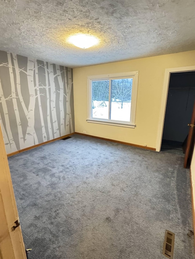 unfurnished bedroom featuring carpet flooring and a textured ceiling