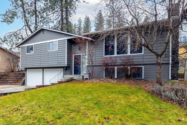 raised ranch featuring a front yard and a garage