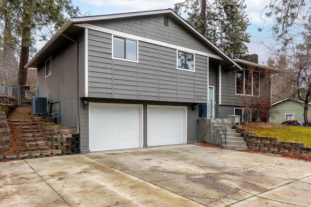 view of home's exterior with central AC and a garage