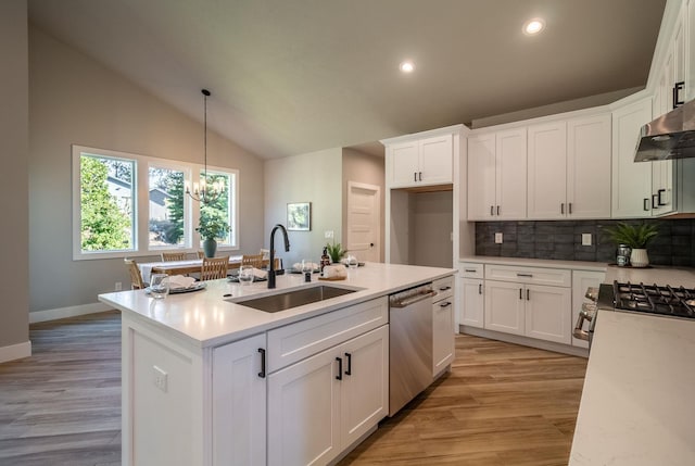 kitchen featuring white cabinetry, sink, hanging light fixtures, stainless steel appliances, and vaulted ceiling