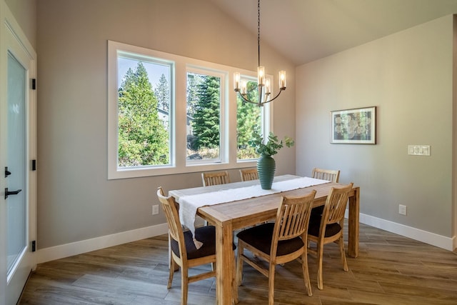 dining area with vaulted ceiling, dark hardwood / wood-style flooring, and a chandelier