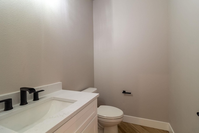 bathroom featuring hardwood / wood-style floors, vanity, and toilet