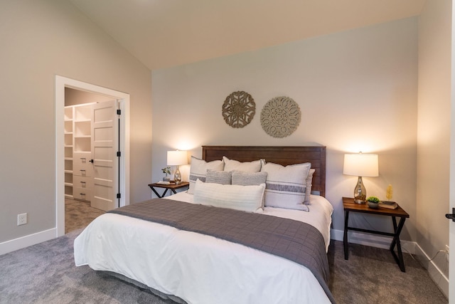 bedroom with carpet flooring, a walk in closet, a closet, and lofted ceiling