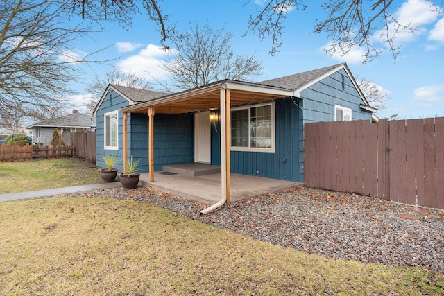 view of front of home with a patio and a front yard