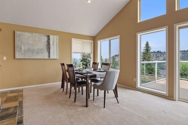 carpeted dining area featuring vaulted ceiling