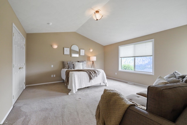 bedroom with light colored carpet and vaulted ceiling