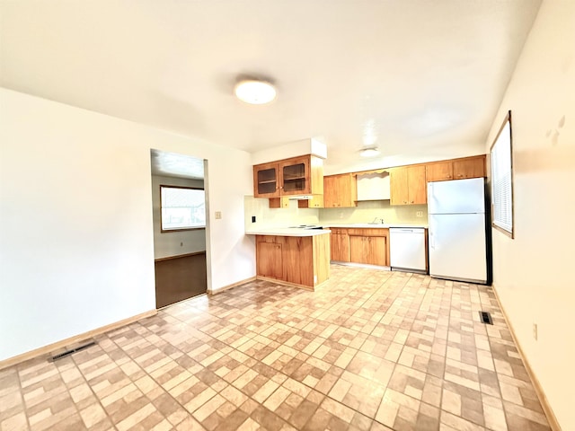 kitchen with kitchen peninsula, white appliances, and sink