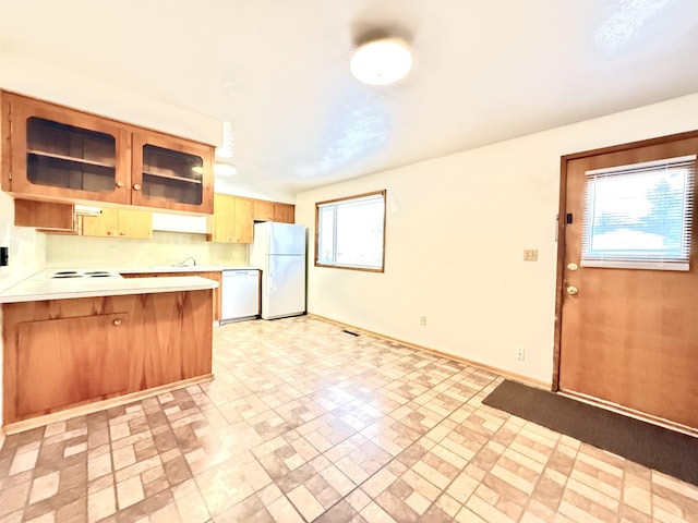 kitchen with a kitchen bar, white appliances, and kitchen peninsula