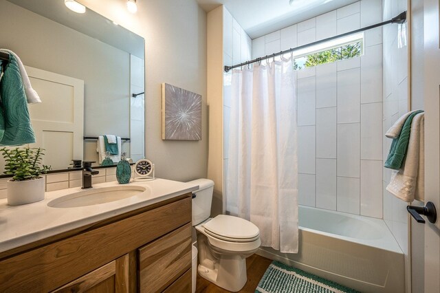 full bathroom featuring shower / bathtub combination with curtain, hardwood / wood-style flooring, vanity, and toilet