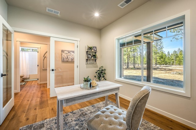 office space featuring french doors, a wealth of natural light, and hardwood / wood-style floors